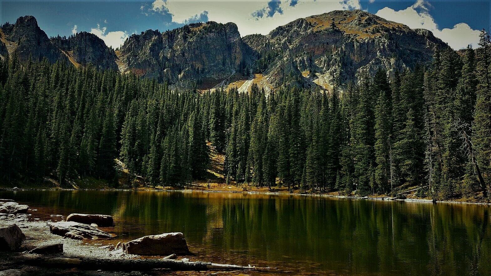 A mountain range with a lake in the foreground.