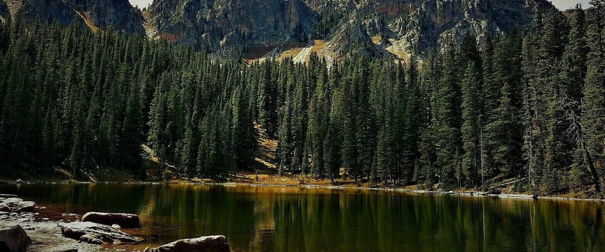 A mountain range with a lake in the foreground.