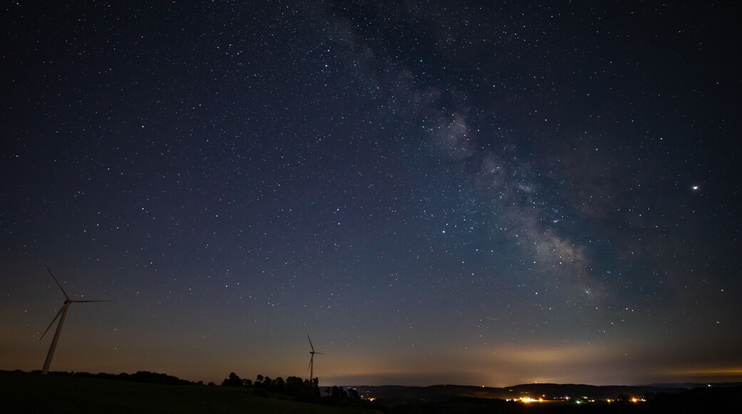 Milky Way photographed on clear sky night near a wind farm