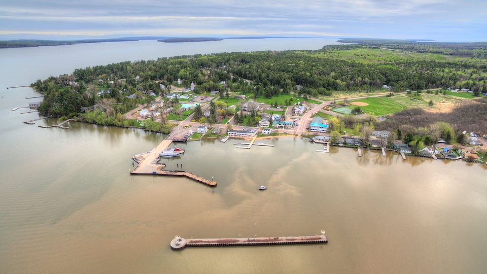 An aerial view of a lakeside community with docks, boats, and houses.