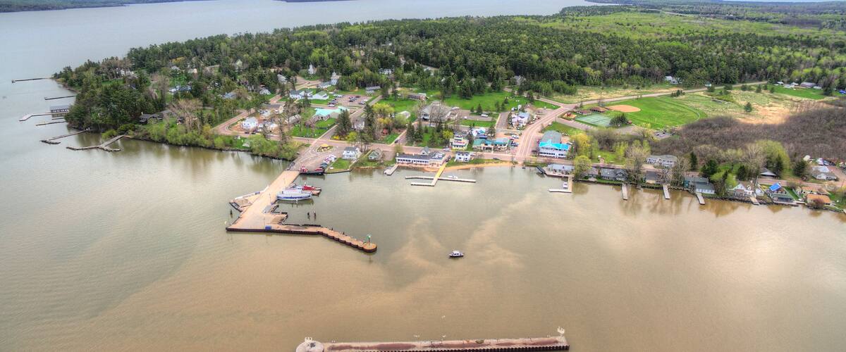 An aerial view of a lakeside community with docks, boats, and houses.