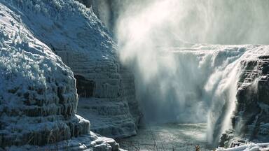 Una cascada congelada con formaciones de hielo en los laterales.