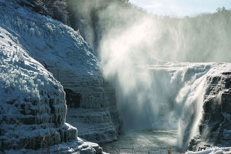 A frozen waterfall with ice formations on the sides.