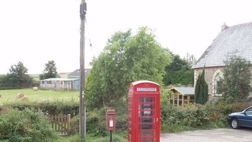 Red Phone box and letter box, Rosenannon. In the centre of the village, with the Methodist Church on the right. The letter box is a "lamp box", so called because it was designed to be attached to a lamp post, though this one has its own post. It has the E II R cipher.