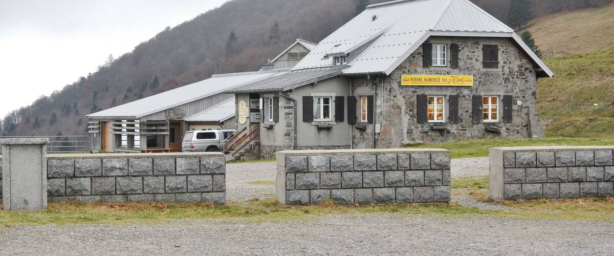 A stone building with a sign reading "Ferme Auberge du Gagn."
