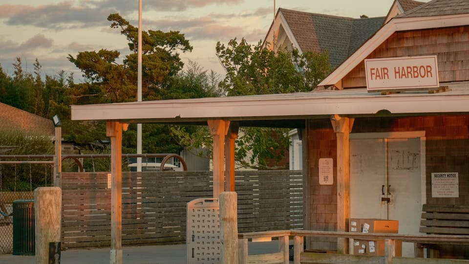 A wooden pier with a sign reading "Fair Harbor" and an American flag.