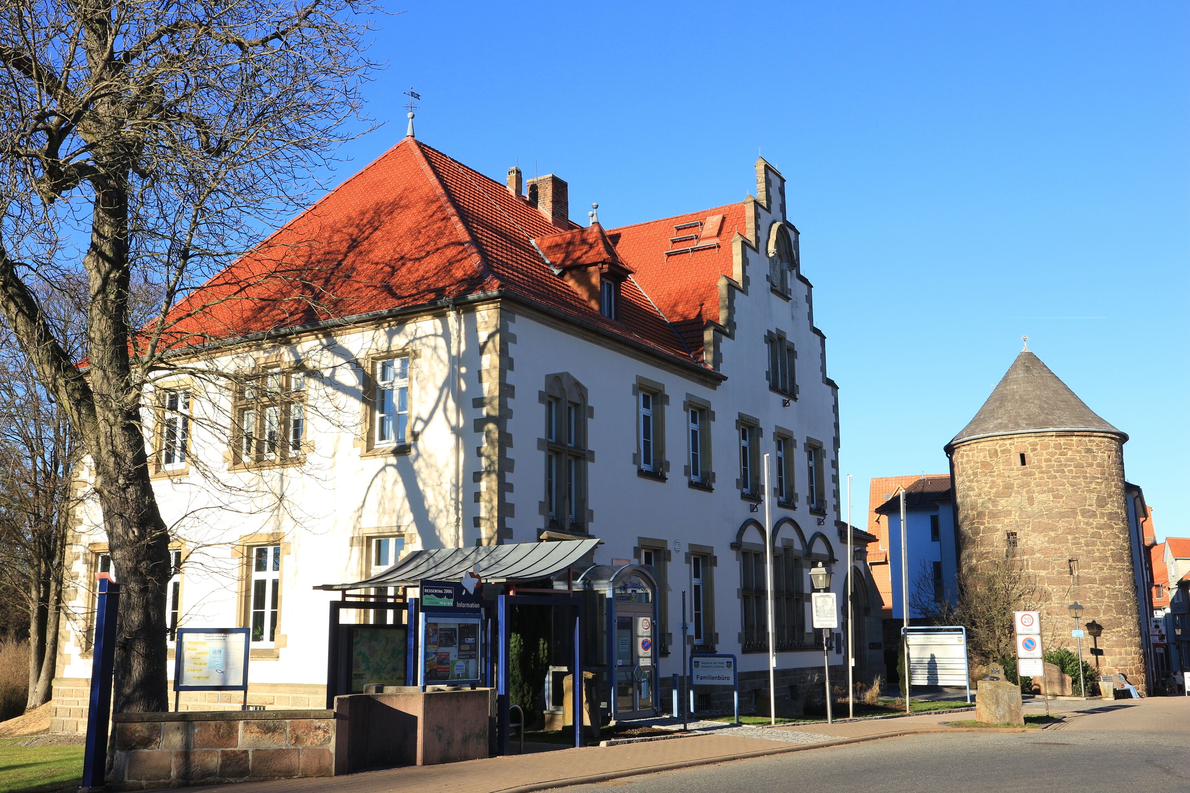 A historic building with a red roof and a stone tower.