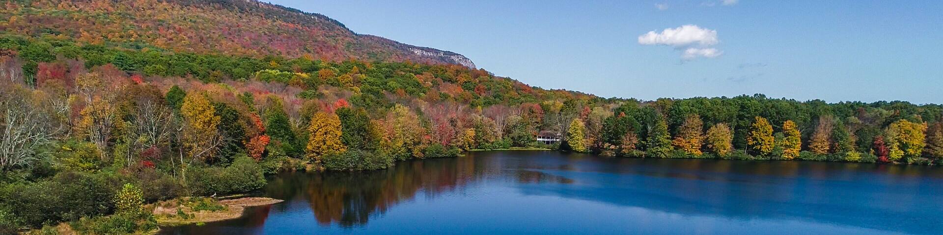 Aerial drone view of lake in autumn state park.