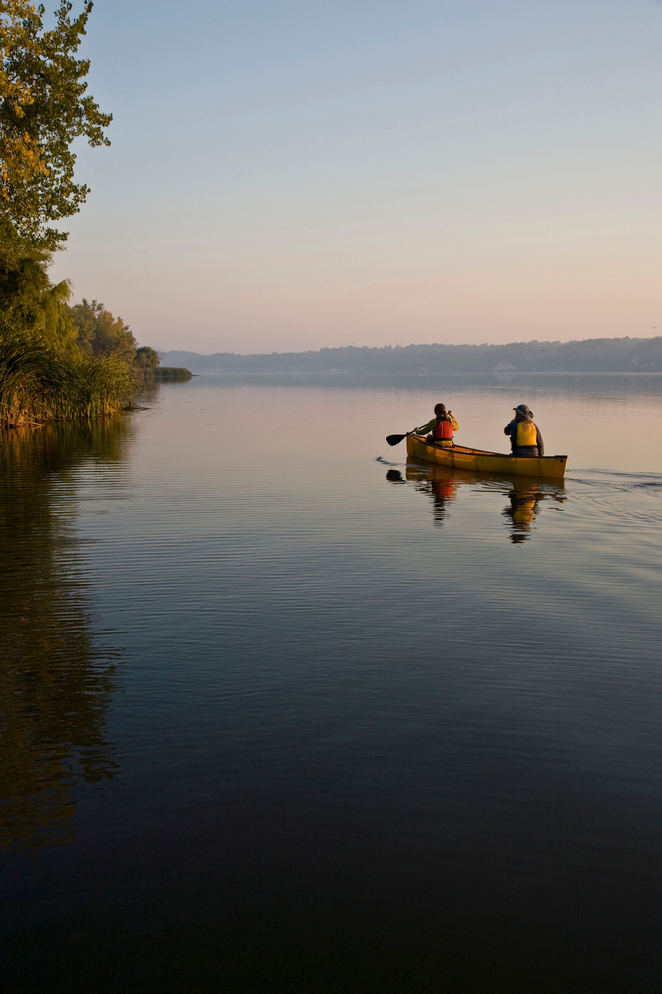 Young couple canoeing in Irondequoit Bay, Rochester, New York, USA.