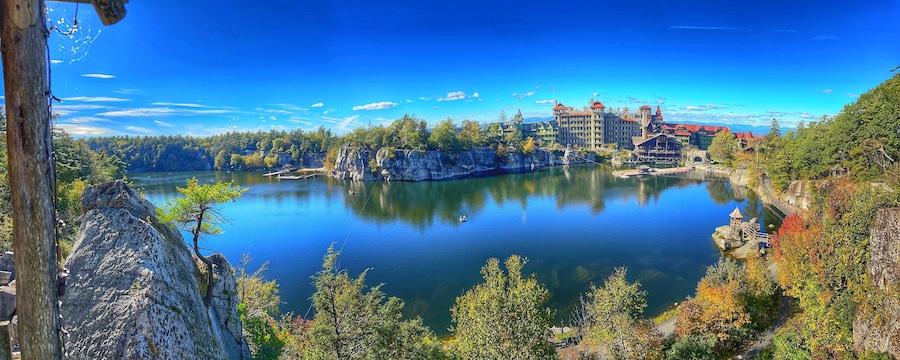 Un lago rodeado de bosque y edificios históricos.