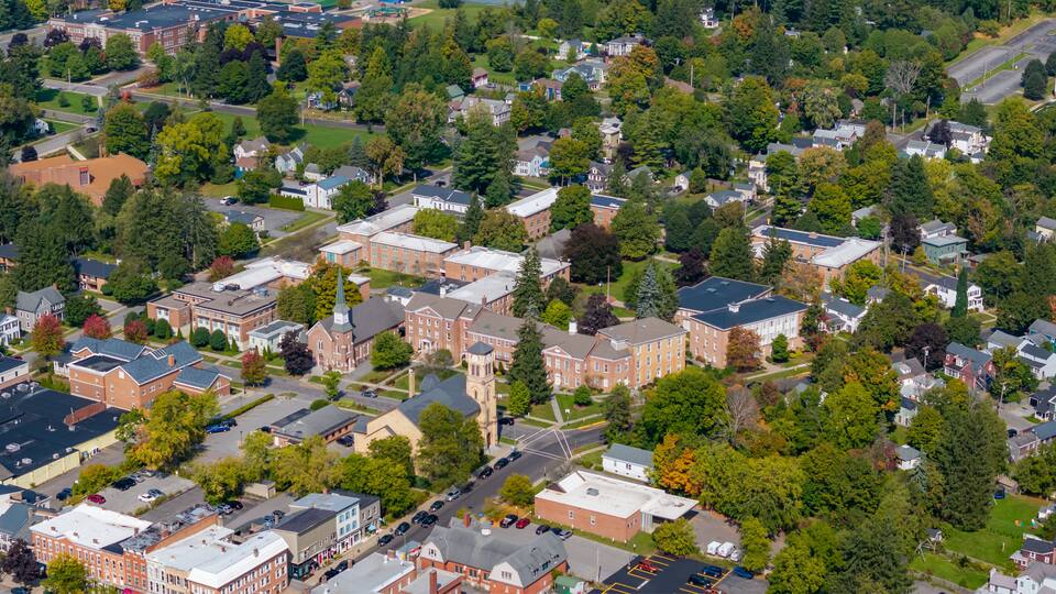 An aerial view of a residential area with houses, a church, and a large building with a steeple.