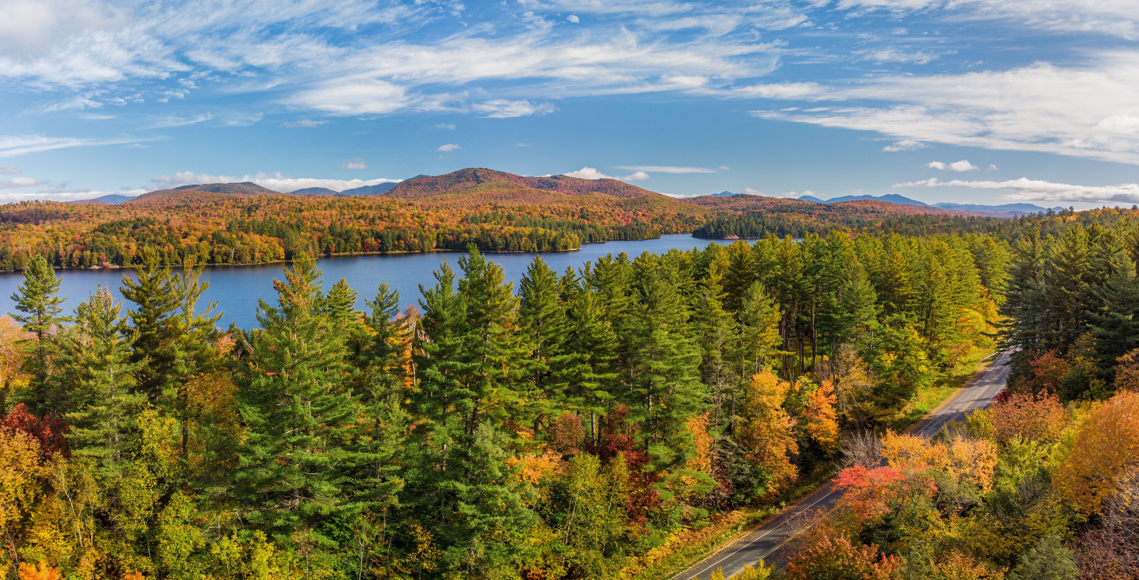 A lake surrounded by autumn-colored trees and mountains.