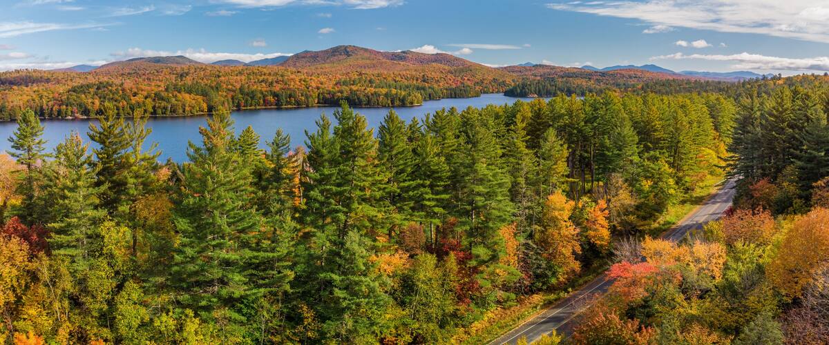 A lake surrounded by autumn-colored trees and mountains.