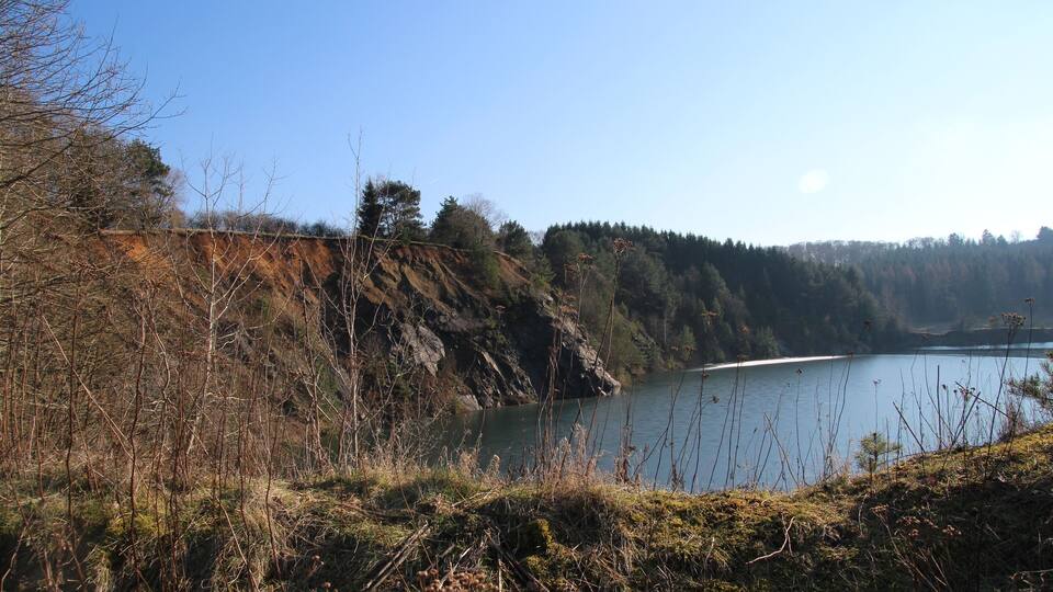 A lake surrounded by rocky cliffs and sparse vegetation.
