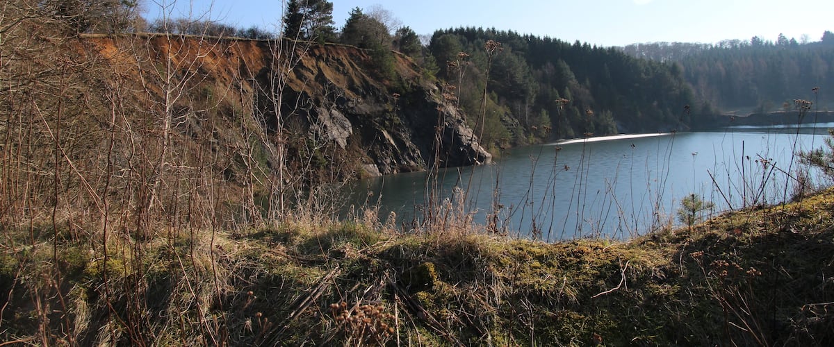 A lake surrounded by rocky cliffs and sparse vegetation.