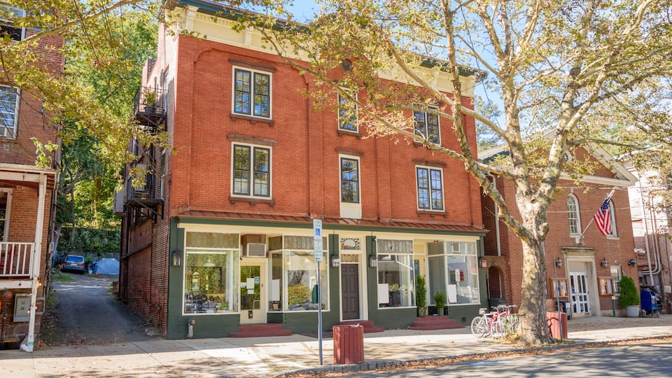 A historic brick building with green trim and a storefront.