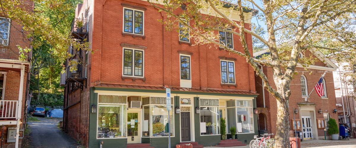 Traditional American brick buildings with shops on ground floor along a tree lined street in a historic downtown on a sunny autumn day
