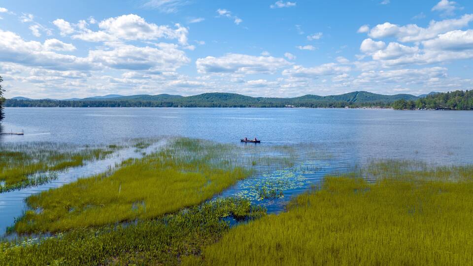 Aerial view of Lake Pleasant in Speculator, New York with couple in a canoe. July 10, 2022