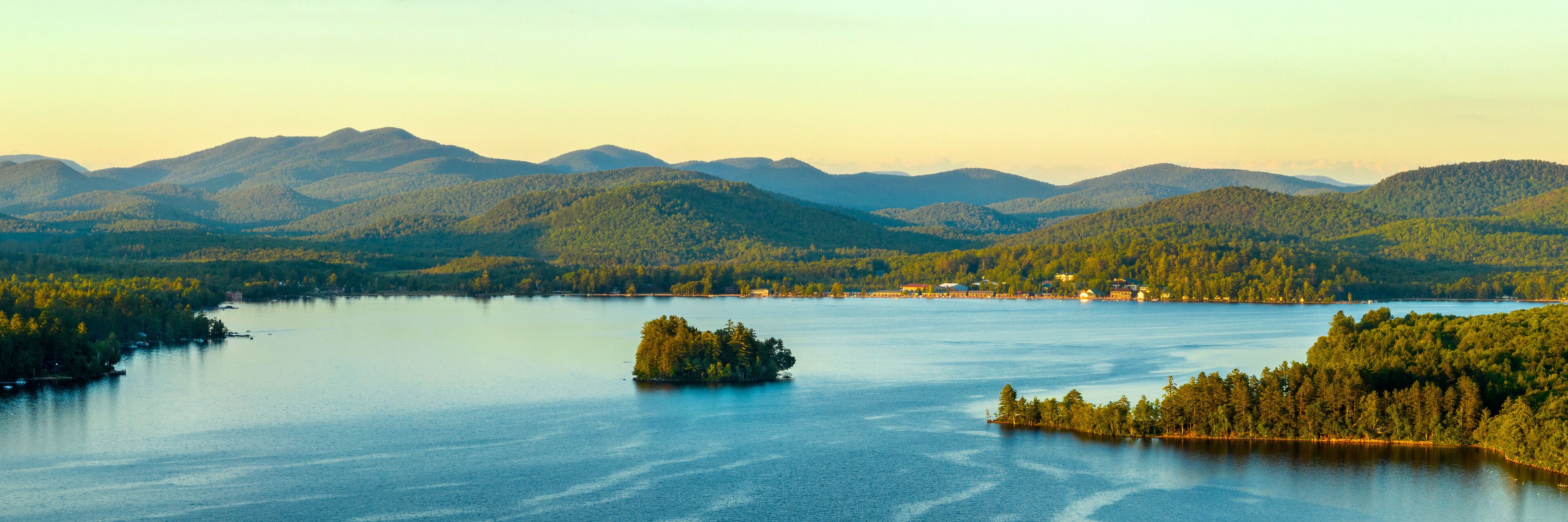 A lake surrounded by forested mountains.