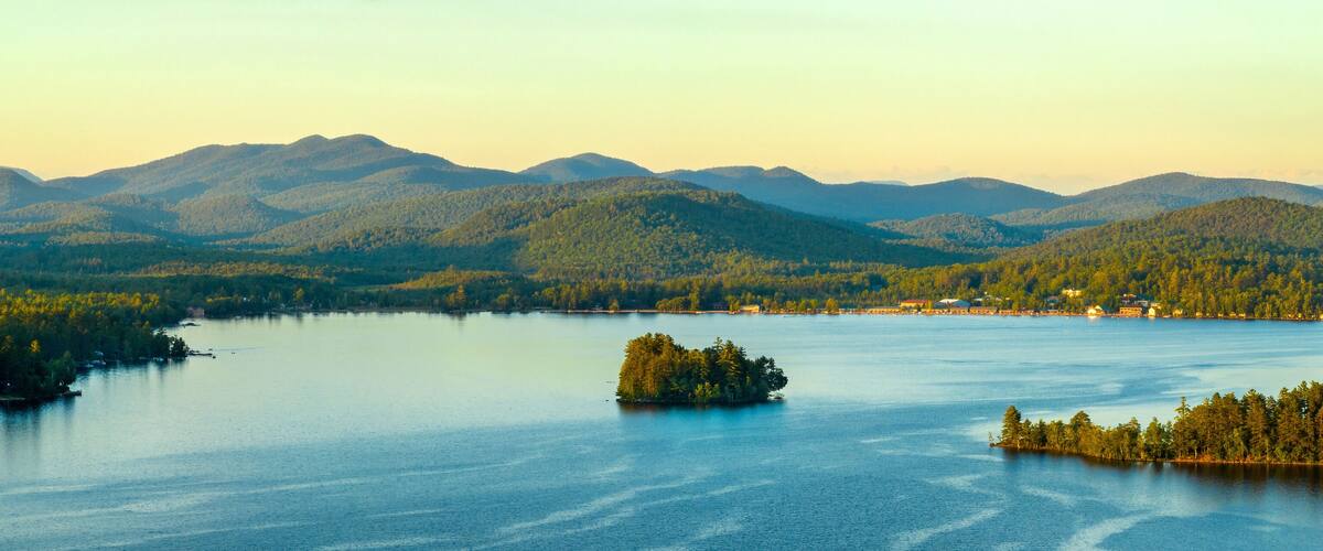 A lake surrounded by forested mountains.