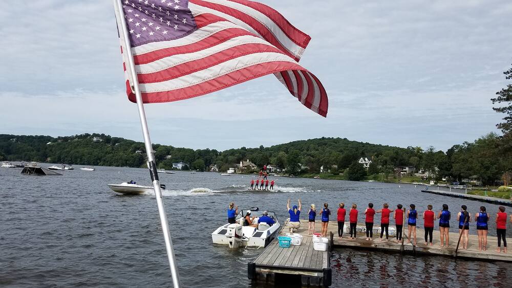 American Flag Blowing in the Wind with a Lake and Boating Background; Travel and Vacation Destinations; American Culture