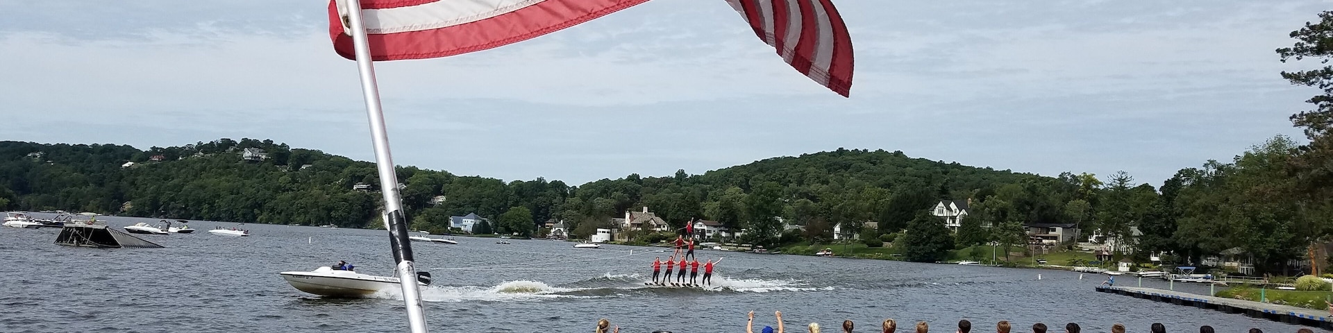 American Flag Blowing in the Wind with a Lake and Boating Background; Travel and Vacation Destinations; American Culture