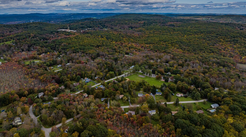 Aerial view of the countryside in Stormville, New York on a day with dark clouds, during the colorful autumn season.