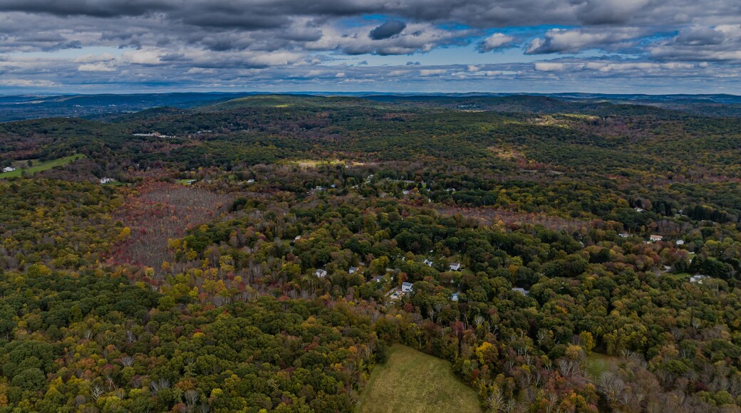 Aerial view of the countryside in Stormville, New York on a day with dark clouds, during the colorful autumn season.