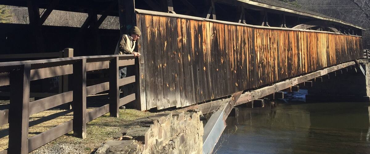 A wooden covered bridge over a river.