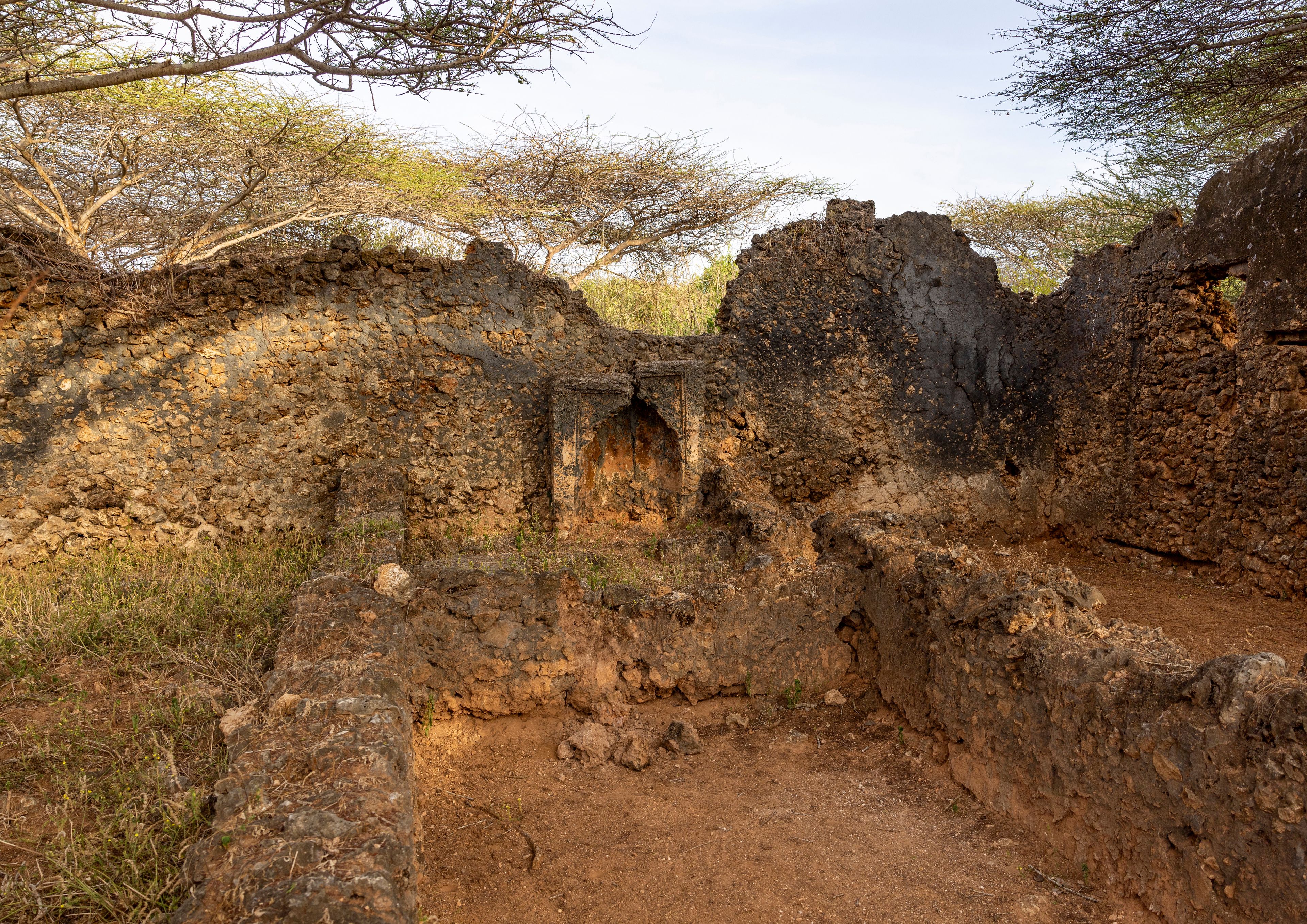 Ancient ruins with stone walls and a cave-like structure.
