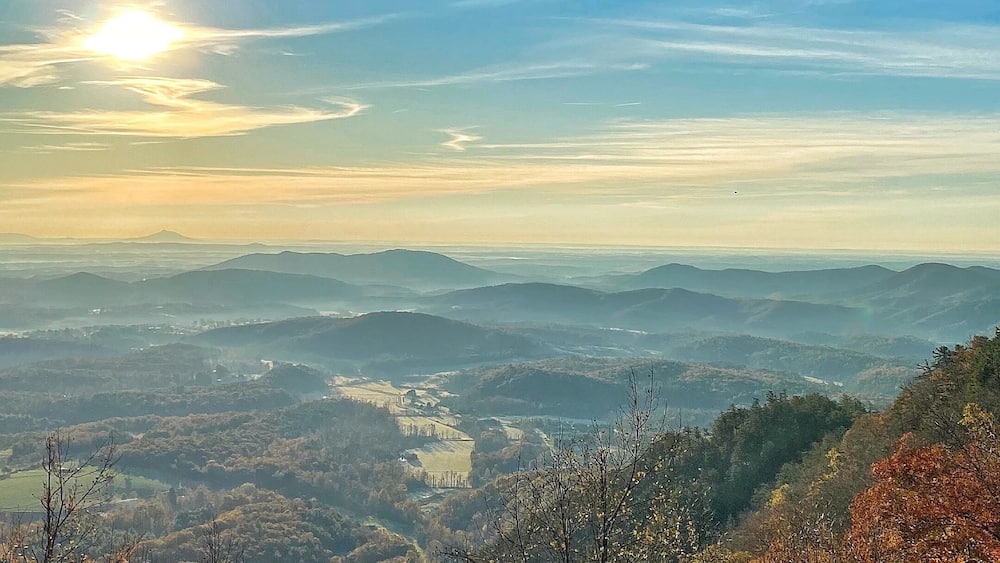 A mountainous landscape with autumn foliage and a clear sky.