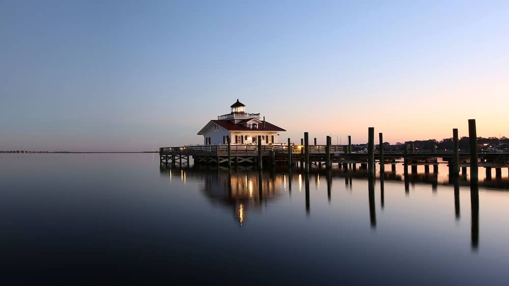 A lighthouse on a pier at dusk.