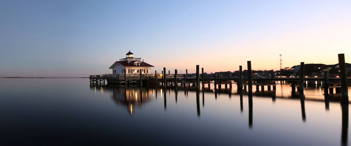 A lighthouse on a pier at dusk.