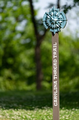 Carolina Thread Trail sign on a greenway with a shallow depth of field and copy space