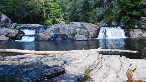 The smaller falls at Linville Falls in North Carolina, USA. The hike is pretty easy and you get great views of the mountains and the falls. You are not allowed to swim in that refreshing looking pool unfortunately but the views are nice! There is a nice parking lot where you can leave your car and there is no fee to hike the trails (as far as I remember).