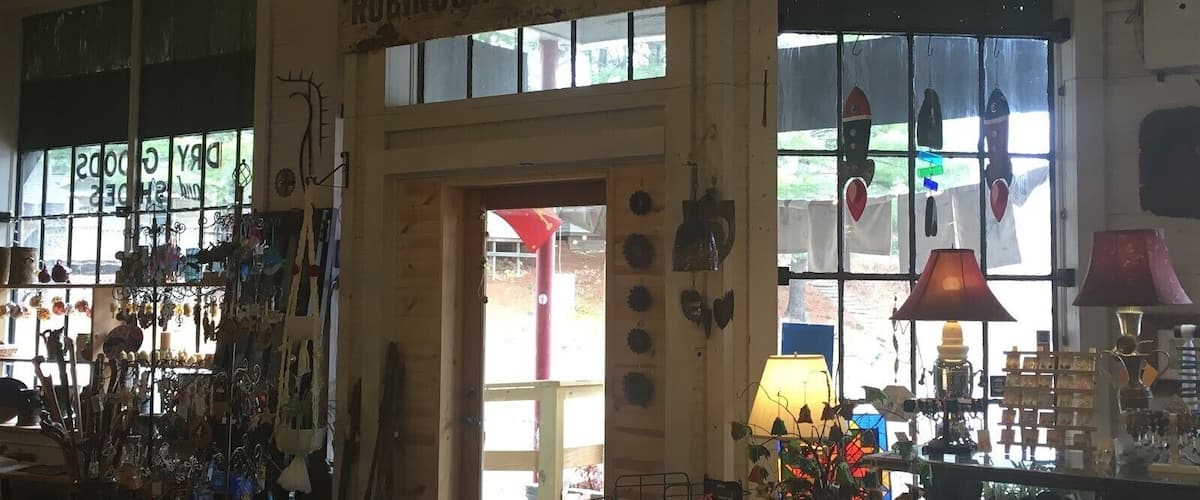 A vintage shop interior with a sign reading "Robinson Gen. Tasse" and various items on display.