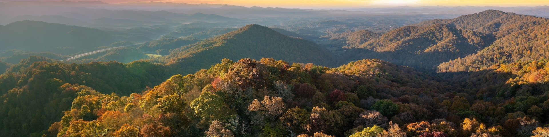 Wooded sunset hills of Appalachian mountains in North Carolina with lush and evergreen forest trees at fall season. Beauty of autumnal nature
