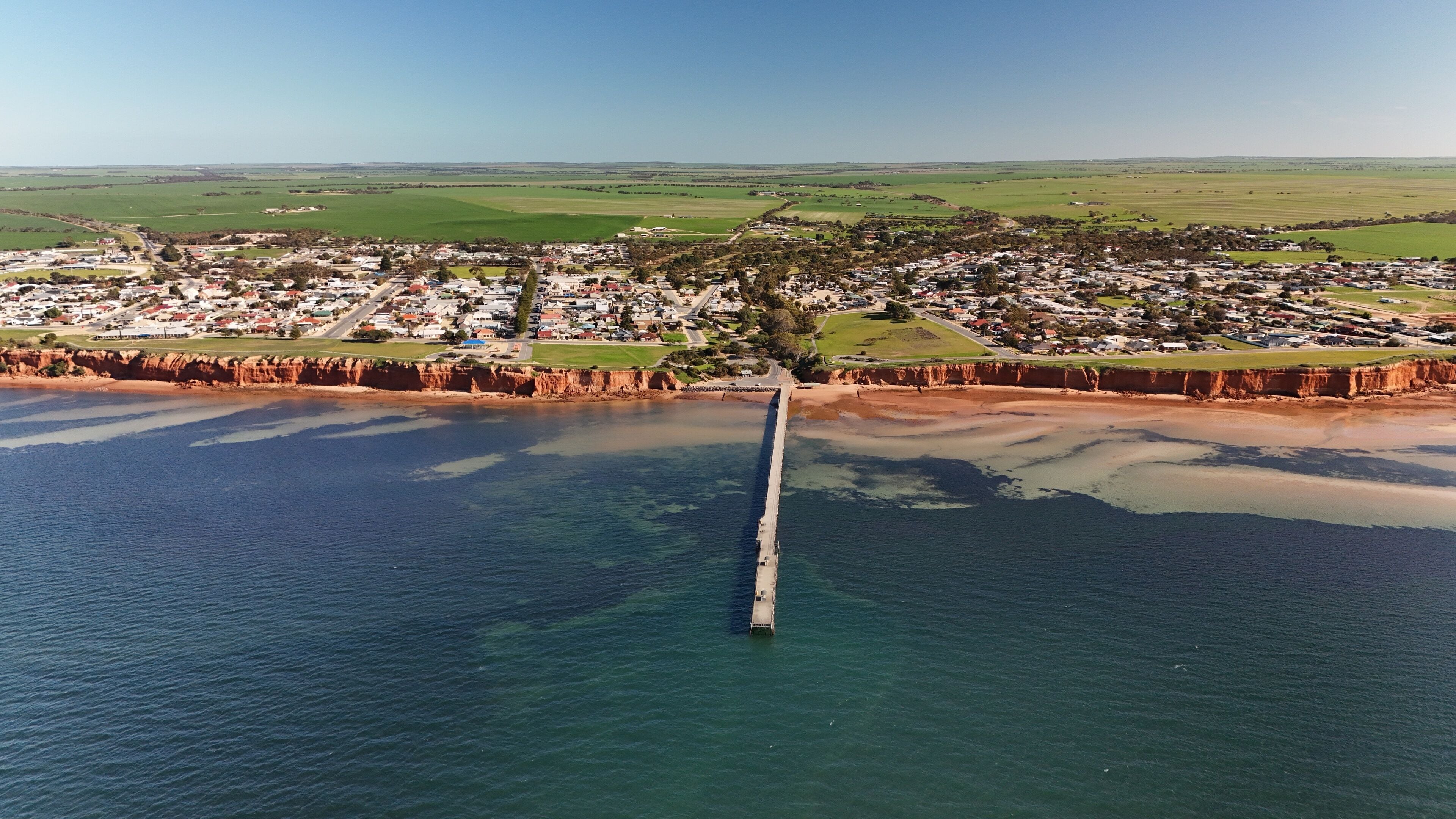 Ardrossan, Yorke Peninsula, South Australia: Aerial Drone View of Coastal Red Cliffs, Jetty, Sandy Shoreline, and Picturesque Seaside Town with Farmland Backdrop