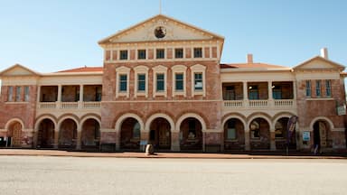 Un grand bâtiment historique doté d’un fronton central, de plusieurs arcades et d’un drapeau.