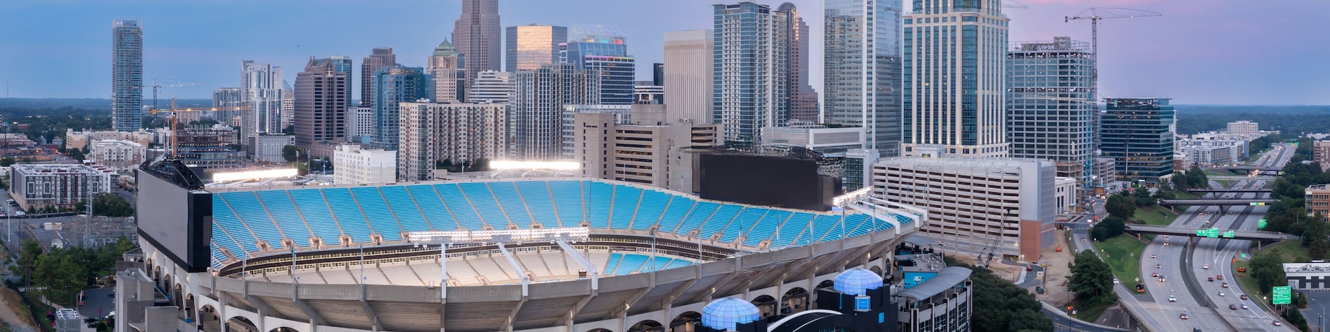 Une vue sur les toits dâune ville, avec un grand stade et des gratte-ciel modernes.