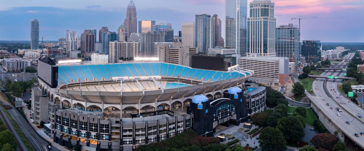 A city skyline with a large stadium and modern skyscrapers.