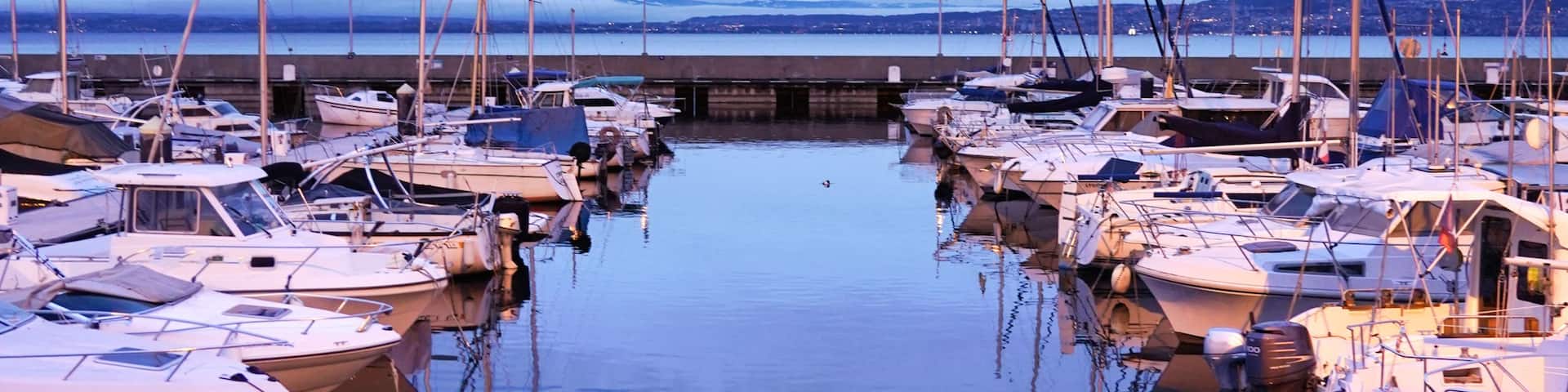 A marina with boats docked and a clear sky.