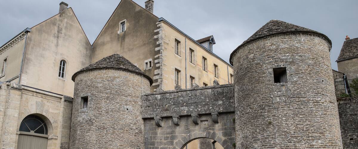A historic stone castle with a large arched entrance and two round towers.