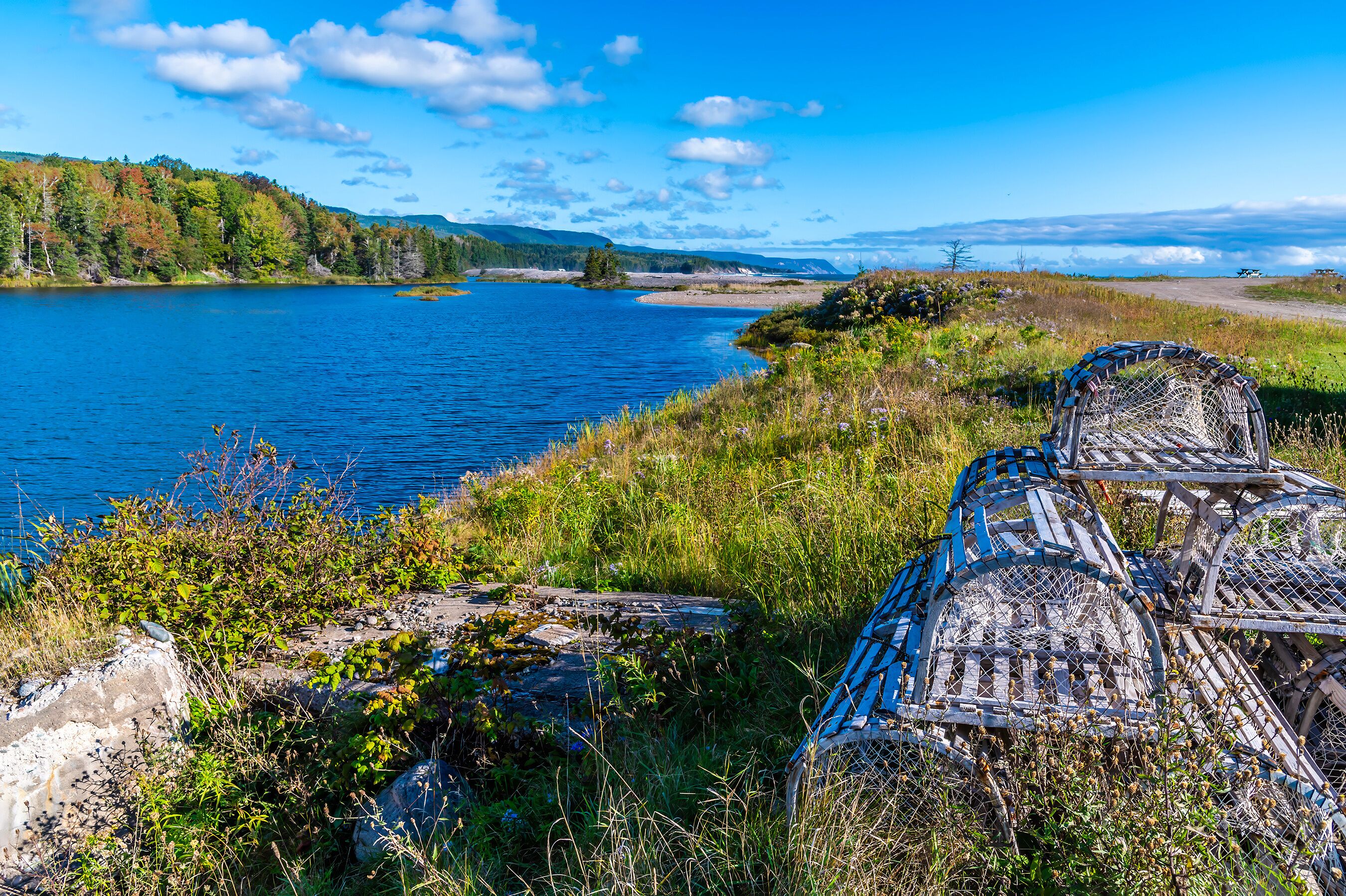 A lake with a wooden structure in the foreground and a forested hill in the background.
