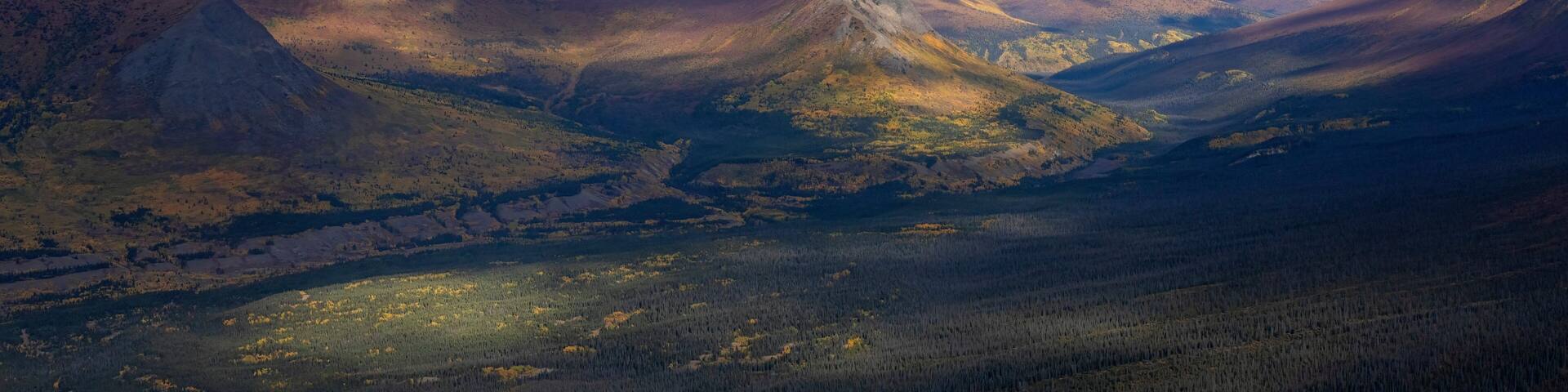 Stunning aerial view of the Ruby Range under heavy clouds near Destruction Bay, with autumn setting in on the Yukon landscape; Destruction Bay, Yukon, Canada