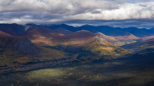 Stunning aerial view of the Ruby Range under heavy clouds near Destruction Bay, with autumn setting in on the Yukon landscape; Destruction Bay, Yukon, Canada