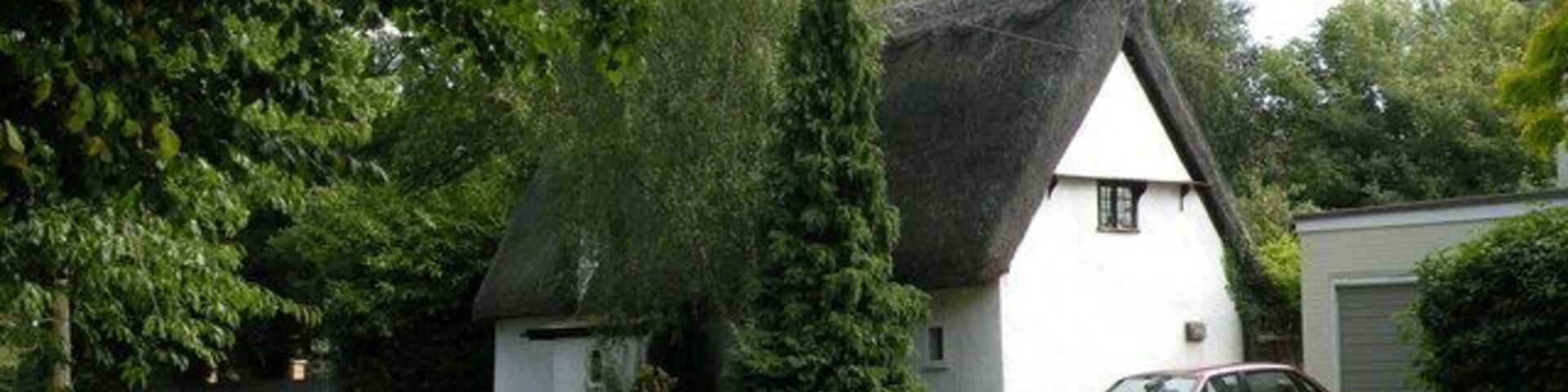 Tudor Cottage, Frog End Late C17 or C18 (but who ever heard of a Stuart or Hanoverian cottage?). Roughcast rendered timber frame with chamfered roof of long straw, half-hipped to left hand gable end. Original grey gault brick ridge stack. Grade II listed, LBS Number: 51506. http://www.heritagegateway.org.uk/Gateway/Results_Single.aspx?resourceID=5&uid=51506
