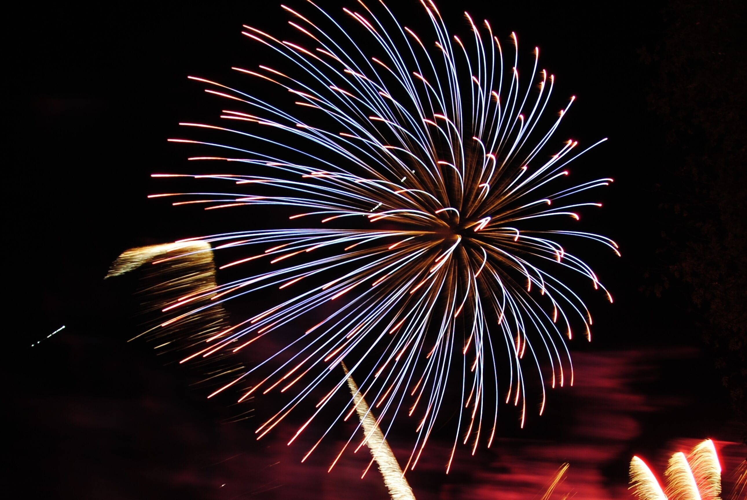 A firework display with a dark background and bright, colorful trails.