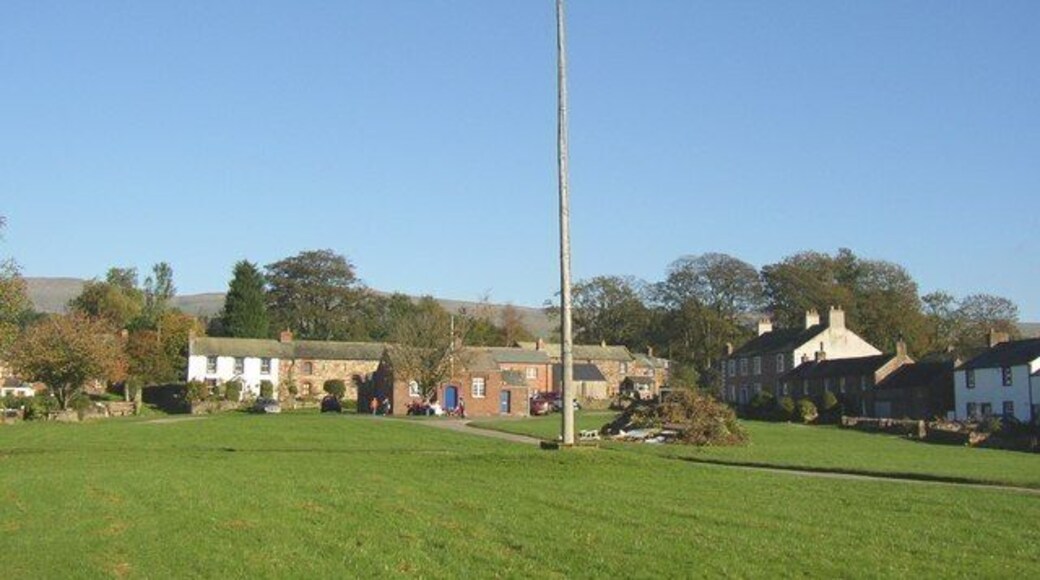 Maypole, Milburn A very tall pole on the village green, with the tiny school behind it and a bonfire in the making..