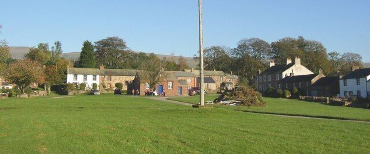 Maypole, Milburn A very tall pole on the village green, with the tiny school behind it and a bonfire in the making..
